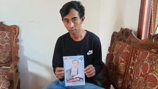 
					Herwanto ayah dari Rafael Aditya, saat menunjukan foto putranya yang saat ini hilang. (foto: IST)