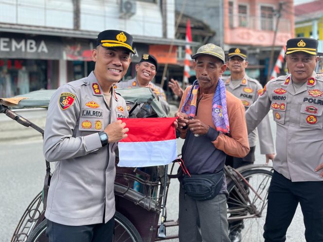 
					Kapolres OKU Selatan, AKBP I Made Redi Hartana, S.H., S.I.K., M.I.K., saat terjun langsung membagikan bendera merah putih di jalan raya pasar Muaradua.