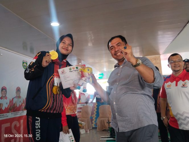 
					Bupati OKU Selatan Abusama saat foto bersama atlet angkat besi  OKUS Marta Lena yang menyumbangkan mendali emas perdana di Porprov 2025.