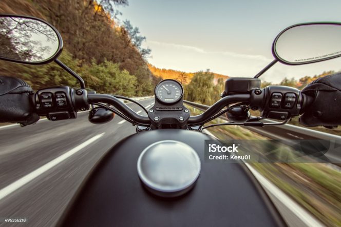 
					The view over the handlebars of motorcycle. Travel theme.